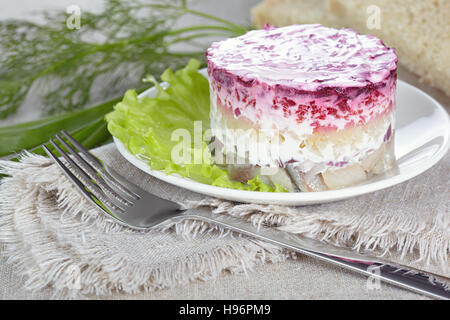 Insalata "aringa sotto una pelliccia"su una piastra bianca Foto Stock