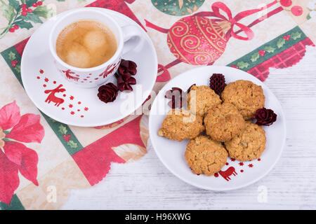 Natale tazza di caffè e i biscotti su una tovaglia di festa Foto Stock