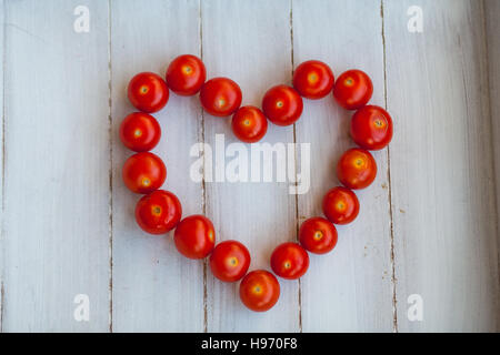 Mature di pomodori ciliegini disposte a forma di cuore Foto Stock