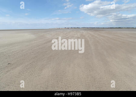 Blue sky nuvole bianche visualizza il vento soffia sabbia asciutta su vasta distesa di spiaggia di sabbia verso la costa a St Annes, Lancashire, Regno Unito Foto Stock