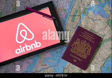 Airbnb logo sul tablet con mappa e passaporto, Londra Foto Stock