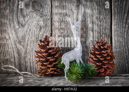 Home decor pigne e cervo bianco su uno sfondo di legno. Foto Stock