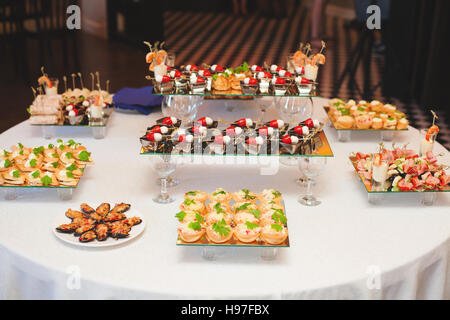 Tavolo con assortimento di tartine snack. Servizio banchetti. Foto Stock