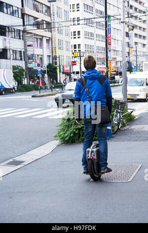 Il popolo giapponese in piedi e equitazione monociclo sul sentiero accanto al traffico stradale a Shinjuku city il 19 ottobre 2016 a Tokyo, Giappone Foto Stock