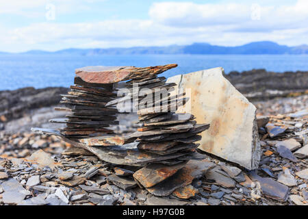 L'ardesia impilato sulla riva, Cullipool, Luing Foto Stock