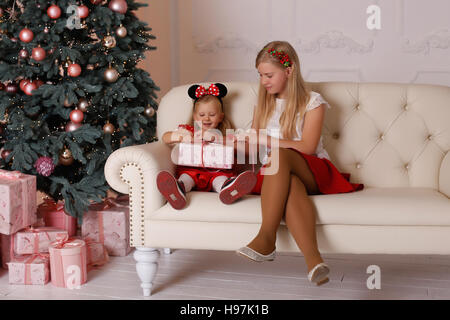 Sorelle ragazze seduta sul divano con i regali di Natale in mani Foto Stock