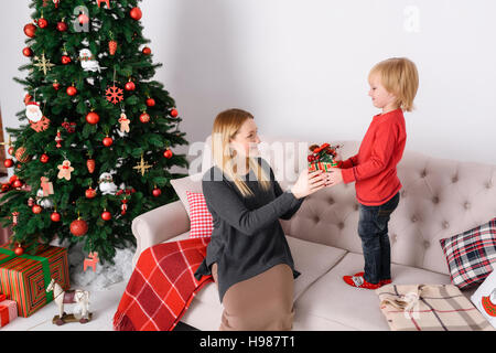 Mom fornisce un bambino regali di Natale Foto Stock