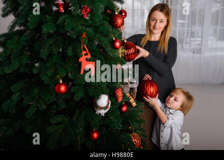 Madre e figlio decorare albero di Natale Foto Stock