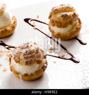 Due eclairs con vaniglia favore su sfondo bianco Foto Stock