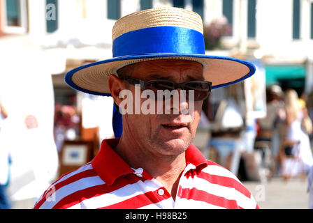 Gondoliere con il tipico copricapo a Canal Grande di Venezia in Italia. Foto Stock