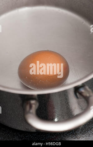 Uovo in acqua in ebollizione in una pentola Foto Stock