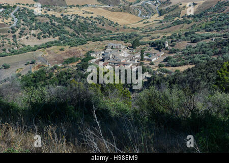 Paesaggi della Sicilia centrale in estate. Con la tipica siciliana di colline e ulivi, con una strada che si snoda attraverso le montagne. Foto Stock