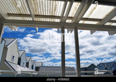 Andando verso nord nel paesaggio nordici: una fila di case costruite in tipica architettura in legno, cielo blu e nuvole Foto Stock