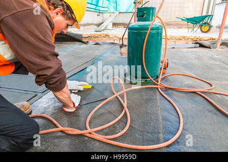 Copritetti installazione di rotoli di impermeabilizzazione bituminosa membrana di impermeabilizzazione di una terrazza Foto Stock
