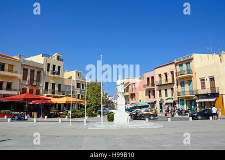 Statua di un soldato sconosciuto in Agia Stratiota Square (Quadrato Agnostou) con caratteristiche caffetterie alla parte posteriore, Rethimno, Creta, Grecia, l'Europa. Foto Stock