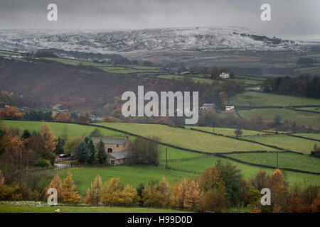 La neve copre le colline come i colori autunnali sono visto sugli alberi vicino a Meltham nel Parco Nazionale di Peak District, West Yorkshire, come gli avvisi meteo sono a posto dopo la tempesta Angus, il primo denominato storm della stagione, hanno causato allagamenti e caos per i servizi di emergenza quando si ha colpito il Regno Unito con raffiche anticipato per arrivare fino a 80km/h. Foto Stock