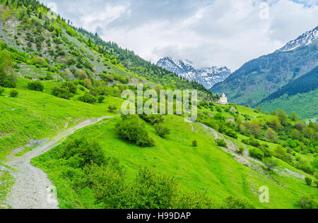 Lo stretto sentiero conduce alla piccola chiesa che si trova sul pendio, Mestia, Georgia. Foto Stock