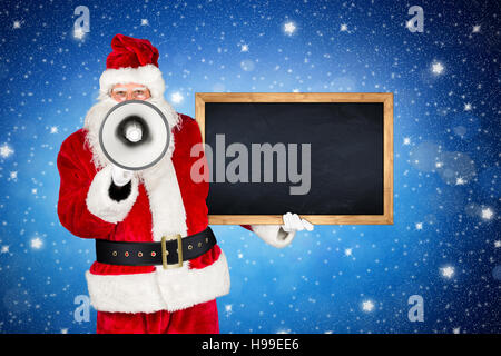 Classico tradizionale rosso bianco santa claus rendendo gridando forte annuncio con bullhorn megafono lavagna in legno nella sua altra mano davanti ho Foto Stock