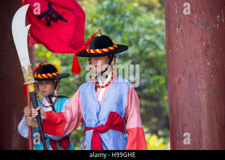 SEOUL, Corea del Sud - 20 ottobre 2016: Palazzo di guardia in costumi tradizionali guardia solennemente l'imponente cancello principale del Palazzo Deoksugung nel centro cittadino di sé Foto Stock