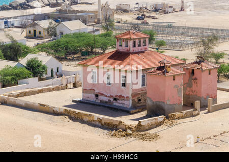 Grande rosa rovinato mansion dal portoghese di epoca coloniale nel piccolo villaggio costiero di Angola il deserto del Namib. Foto Stock