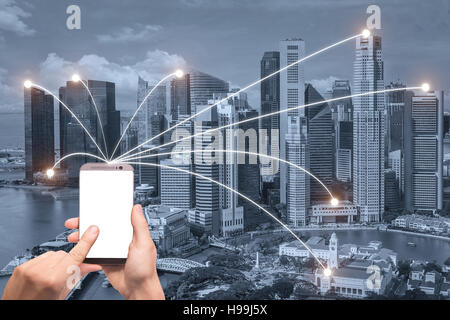 Mano azienda smart phone e Singapore città con connessione di rete. Smart city network connection concetto. Foto Stock