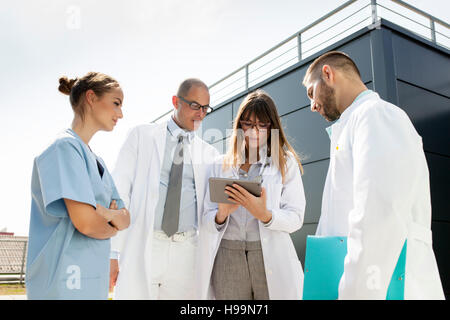 Il gruppo di medici con tavoletta digitale all'aperto Foto Stock
