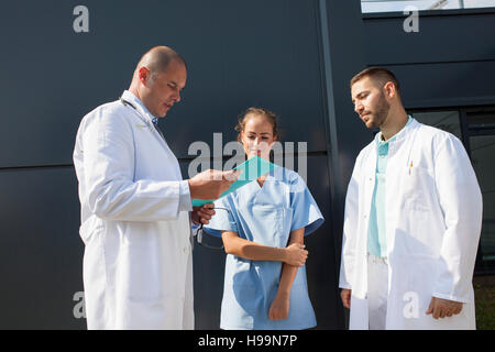 Il gruppo di medici guardando record medici all'aperto Foto Stock