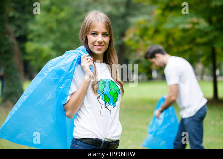 Volontari adolescenti facendo pulizia di immondizia in posizione di parcheggio Foto Stock