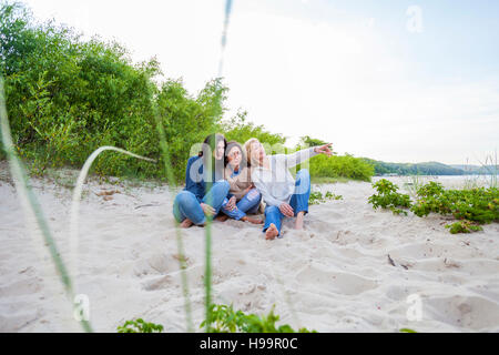 Il gruppo di donne seduto sulla spiaggia sabbiosa Foto Stock