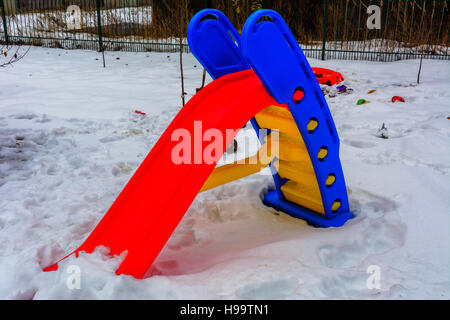 Giocattoli per bambini coperte di neve nel cortile di una casa privata Foto Stock