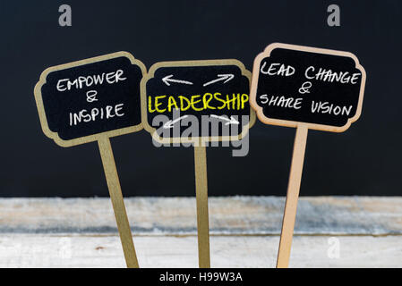 Il concetto di leadership del messaggio scritto con il gesso su legno mini blackboard etichette, lavagna sfocati e tavola di legno in background Foto Stock