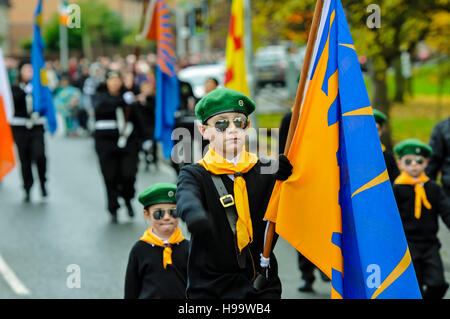 Belfast, Irlanda del Nord. 13 novembre 2016 - i bambini vestiti in uniformi pseudo-paramilitari, compresi berretti verdi, sciarpe arancioni, camicie bianche, jumper neri e occhiali da sole a specchio, partecipano ad una Parata repubblicana irlandese Foto Stock