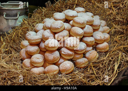 Cumulo di fritto crema bavarese riempito le ciambelle su letto di paglia Foto Stock