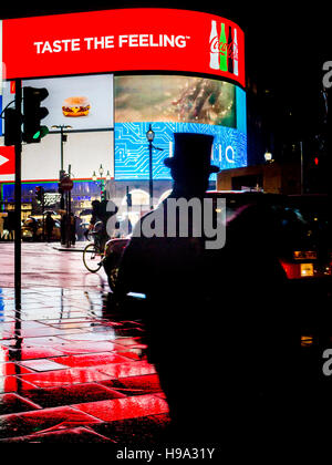 Un uomo in un TopHat a Piccadilly Circus luci nel centro di Londra Foto Stock