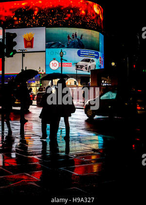 La pioggia riflette Piccadilly Circus luci nel centro di Londra Foto Stock