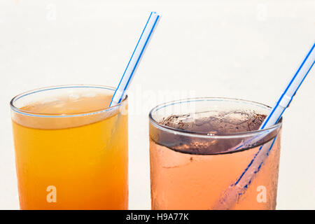 Due cocktail colorati recante sulla sabbia bianca, piccoli coralli spiaggia coperta di fronte all'incredibile acqua turchese dell'indiano oc Foto Stock