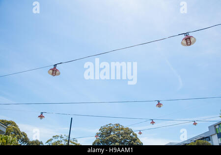 Un abstract colpo di lampioni sospesi da fili contro un cielo blu Foto Stock