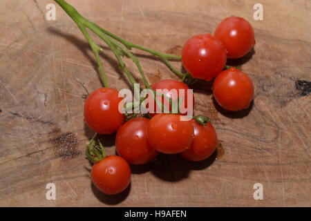 Mature pomodori ciliegia su una tavola di legno Foto Stock