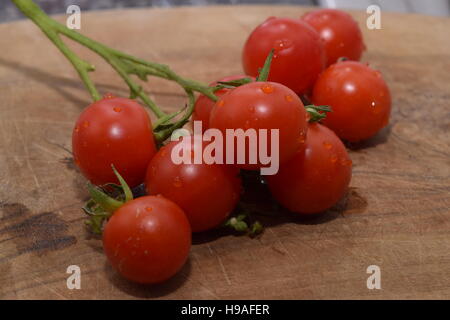 I pomodori su un tagliere di legno Foto Stock