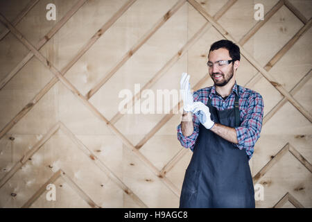 Ritratto di un falegname lavora in officina di indossare un paio di guanti Foto Stock