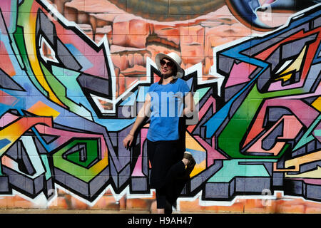 Una donna si trova di fronte a un muro di graffiti in Alice Springs, Territorio del Nord, l'Australia centrale Foto Stock