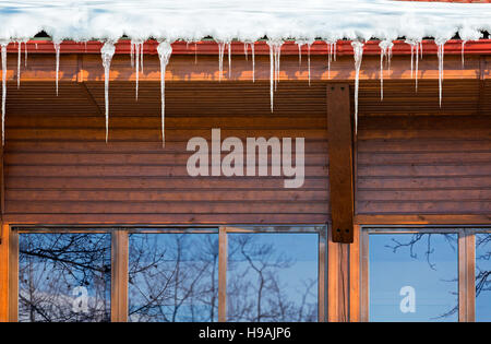 Ghiaccioli appendere da una cabina di legno in una fredda giornata invernale Foto Stock