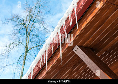 Ghiaccioli appendere da una cabina di legno in una fredda giornata invernale Foto Stock