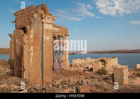 Appena le pareti rimanente dalla villa di lusso sulla costa di un lago di Ouarzazate in Marocco. Nuvoloso inizio del cielo della sera. Foto Stock