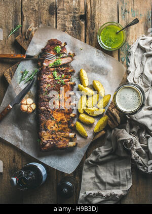 Arrosto di costolette di maiale alle spezie con patate fritte e birra scura Foto Stock