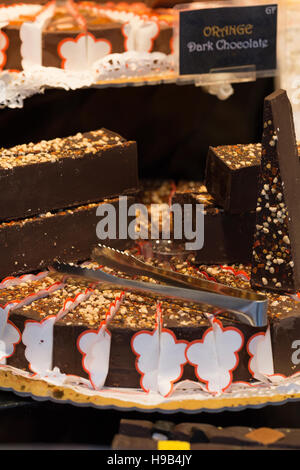 Close up artigianale di mercato degli agricoltori la visualizzazione di crema di cioccolato torta di formaggio impilati con le pinze Foto Stock