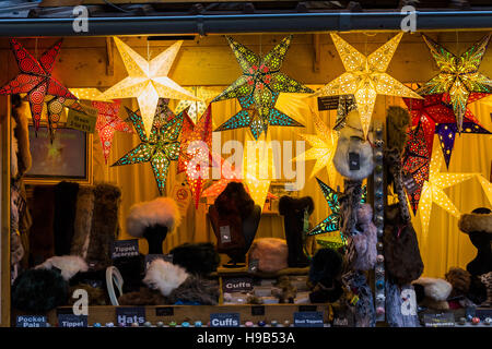 Luminose mercatino di Natale di stallo vendita display inverno con fodera in pelliccia sintetica e accessori colorati lanterne di carta Foto Stock