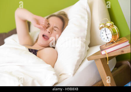 Giovane donna nel letto, dopo il risveglio Foto Stock