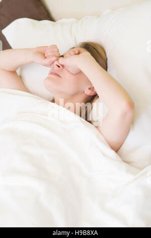 Giovane donna strofinando gli occhi Foto Stock