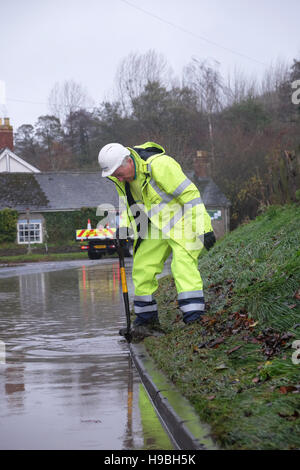 Combe, Herefordshire, UK. 21 Novembre, 2016. Un lavoratore di Herefordshire County Council tenta di cancellare bloccati scarichi stradali sotto l allagamento presso la frazione di Combe tra Shobdon e Presteigne ( Galles ) proprio sul confine di Inghilterra e Galles dopo una notte e la mattina della persistente pioggia pesante. Foto Stock